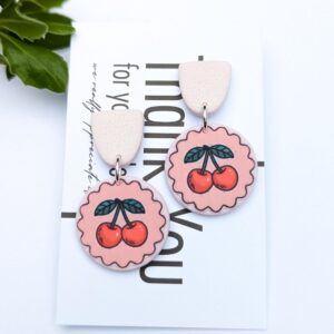 Handmade pink cherry dangle earrings with a scalloped edge.