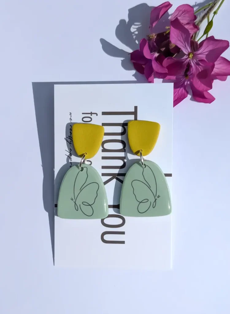 Green earrings with a butterfly design.