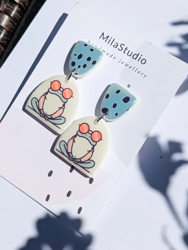 Polymer clay frog jewellery with a blue polka dot stud.