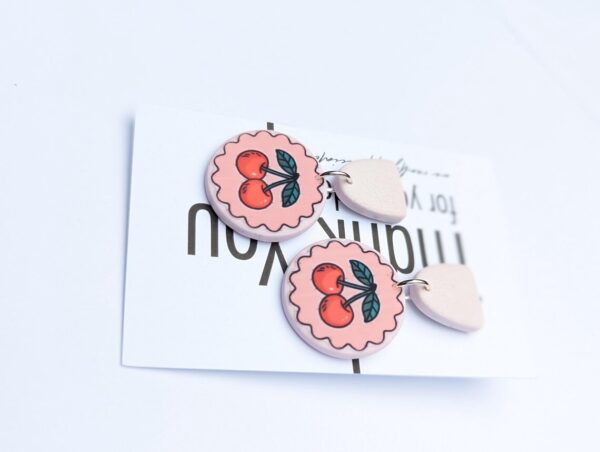 Pink cherry earrings with a playful design, featuring vibrant cherry charms and delicate hooks.