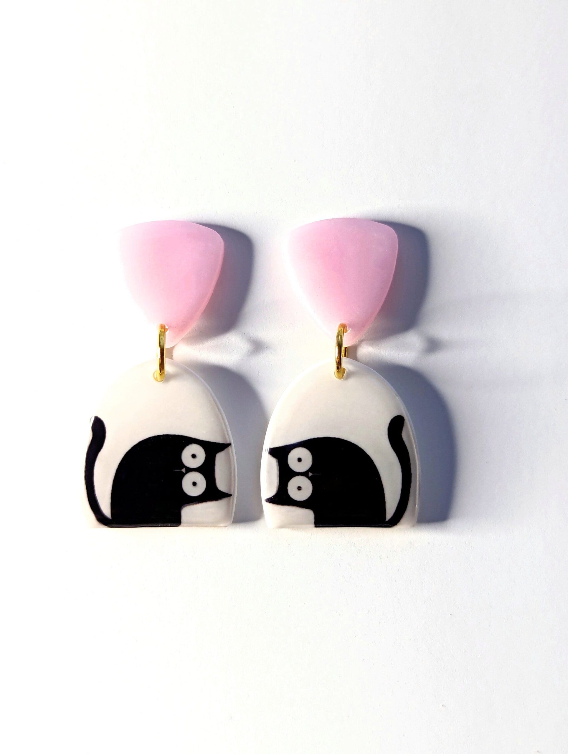 Black and white cat dangle earrings with a pink top.