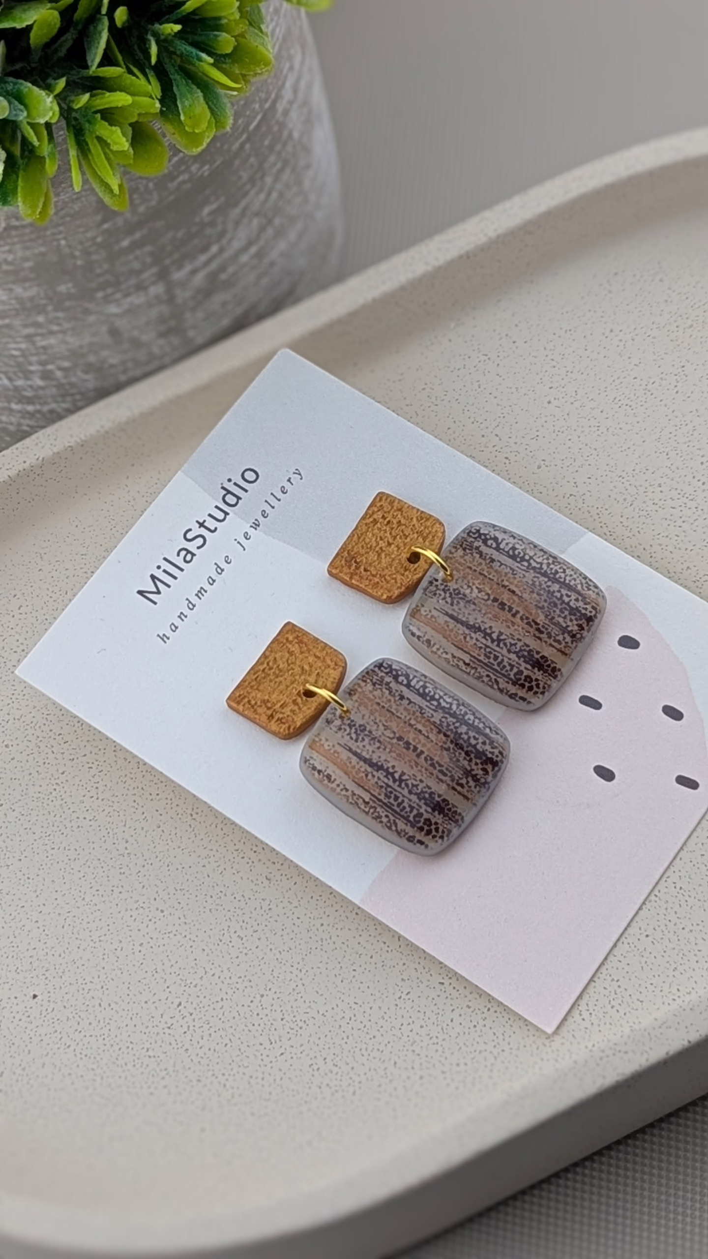 Gold-coloured hammered effect studs on artisan dangle earrings.